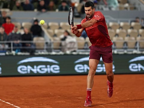 Serbia's Novak Djokovic plays a backhand return to Italy's Lorenzo Musetti during their men's singles match on Court Philippe-Chatrier at the Roland Garros Complex in Paris on Saturday.