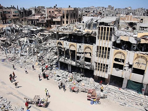 Palestinians carry some salvaged belongings as they leave the Jabalia refugee camp in the northern Gaza Strip after they returned briefly to check on their homes on May 31, 2024.