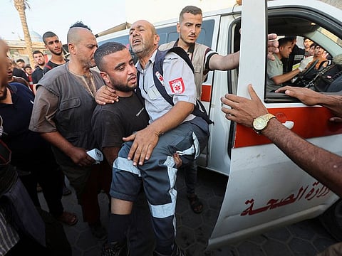 A man carries a Paramedic, who was wounded in an Israeli strike, in Deir Al-Balah in the central Gaza Strip, on June 4, 2024.
