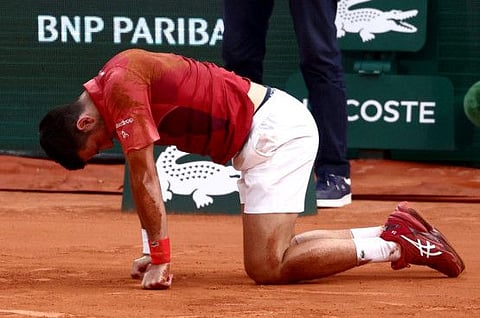 Serbia's Novak Djokovic reacts after falling during his fourth round match against Argentina's Francisco Cerundolo.