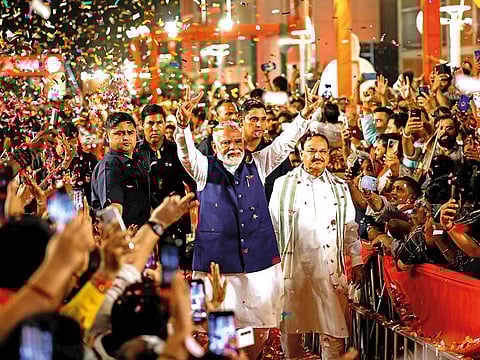 Supporters throw petals on Indian Prime Minister Narendra Modi as he arrives at Bharatiya Janata Party (BJP) headquarters in New Delhi on Tuesday.
