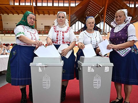 Women in traditional Hungarian dresses cast their ballots at a polling station in a school in Veresegyhaz, some 30km east of Budapest, on June 09, 2024 during the European Parliament election.