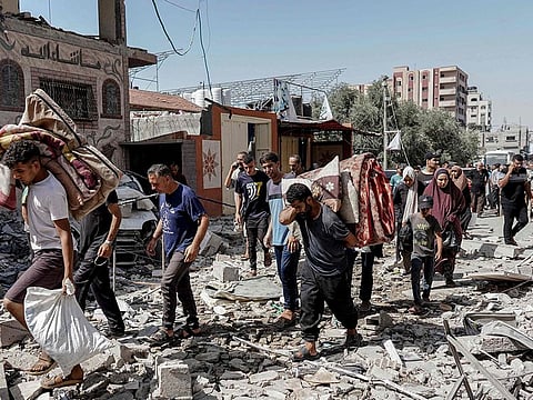 Palestinians evacuate with their belongings following an operation by the Israeli forces in the Nuseirat camp, in the central Gaza Strip on June 8, 2024
