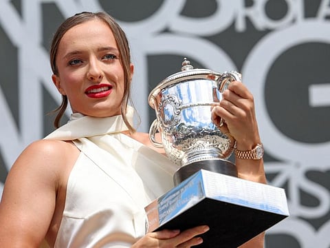 Poland's Iga Swiatek holds the trophy the French Open trophy after winning the women's singles final.