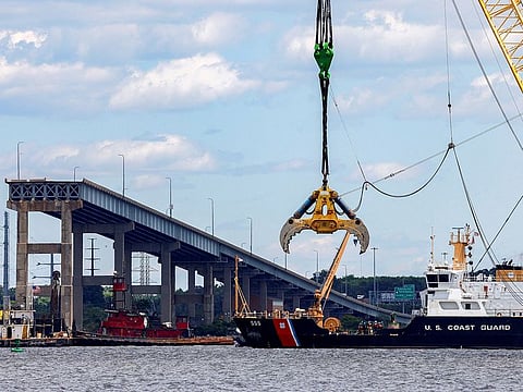A US Coast Guard boat approaches clean-up operations at the Francis Scott Key Bridge as the main shipping channel prepares to fully reopen, in Baltimore, Maryland, on June 10, 2024.