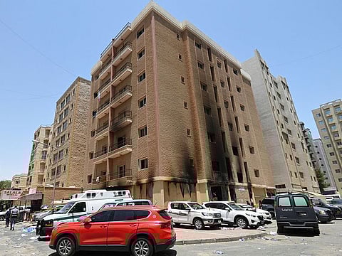 Vehicles are parked next to a building damaged following a deadly fire, in Mangaf, southern Kuwait, June 12, 2024.