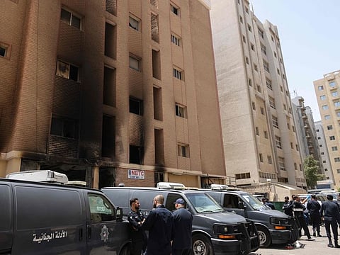 Kuwaiti security forces stand outside a building which was ingulfed by fire, in Kuwait City.