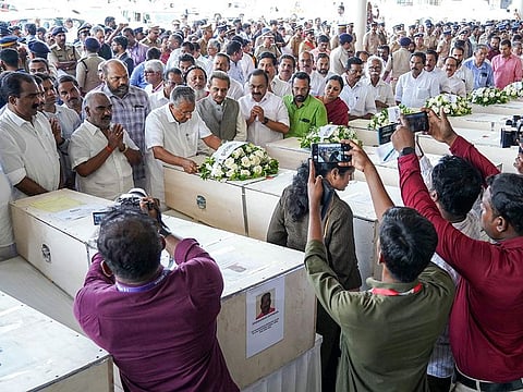 Kerala chief minister Pinarayi Vijayan lays a wreath on the deceased after coffins' arrival on an Indian Air Force plane from Kuwait at the Cochin International Airport in Kochi.
