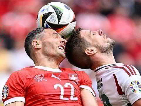 Switzerland's defender #22 Fabian Schaer (L) and Hungary's forward #19 Barnabas Varga both jump to head the ball during the UEFA Euro 2024 Group A football match between Hungary and Switzerland at the Cologne Stadium in Cologne on June 15, 2024.