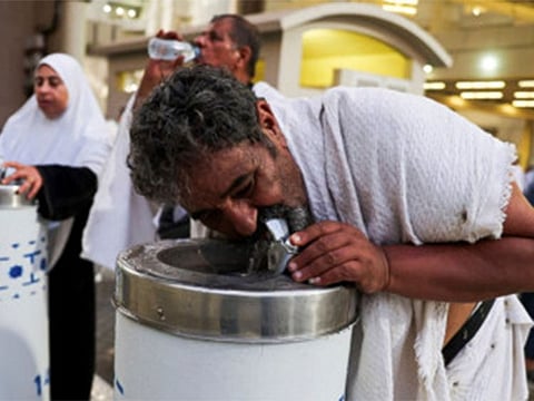 Pilgrims drink water during extremely hot weather, on the first day of the Satan stoning ritual, during the annual Hajj pilgrimage, in Mina.