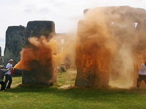 Activists spraying an orange substance at Stonehenge in Wiltshire, southwest England.
