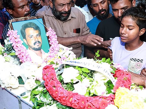 Ashtami , daughter of Arun Babu who lost his life in the Kuwait fire tragedy, near his father's mortal remains, in Thiruvananthapuram.