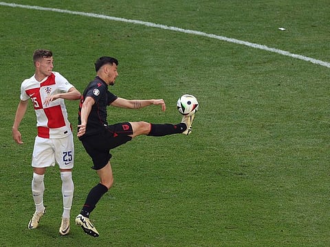 Albania's forward #19 Mirlind Daku shoots the ball past Croatia's midfielder #25 Luka Susic during the UEFA Euro 2024 Group B football match between Croatia and Albania at the Volksparkstadion in Hamburg on June 19, 2024
