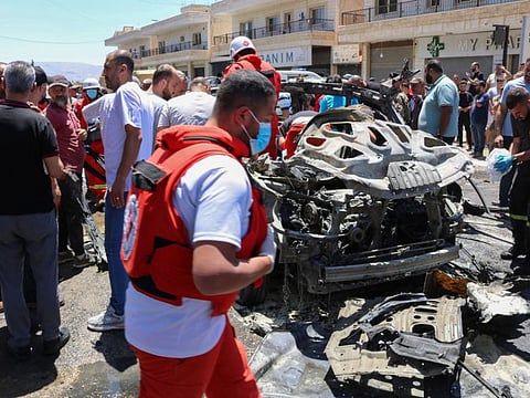 Emergency and security service members and residents gather around the site of an Israeli strike in Al Khiyara town in Lebanon's Western Bekaa area on June 22, 2024.