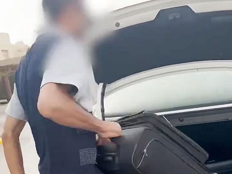 The taxi driver removing the luggage of the passenger who asked him to stop smoking