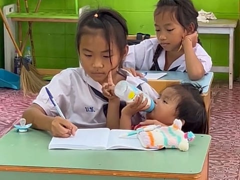 'Green' feeds her baby sister during class
