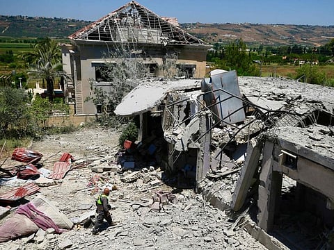 A Lebanese civil defence member inspects the site of an Israeli airstrike on the southern village of Khiam near the Lebanese border with northern Israeli on June 26, 2024.