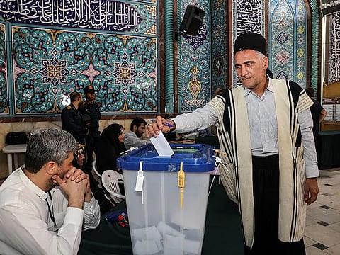 An Iranian man votes at a polling station in a snap presidential election to choose a successor to Ebrahim Raisi following his death in a helicopter crash, in Tehran, Iran June 28, 2024.