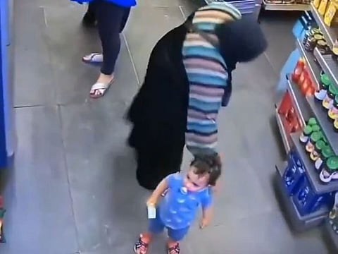 The suspect tries to grab the child in a store.