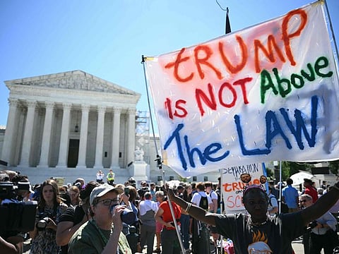 People hold anti Trump signs in front of the US Supreme Court on July 1, 2024, in Washington, DC.