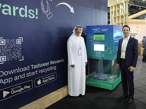 Tadweer officials with one of the many machines installed to collect recyclable waste in Abu Dhabi.