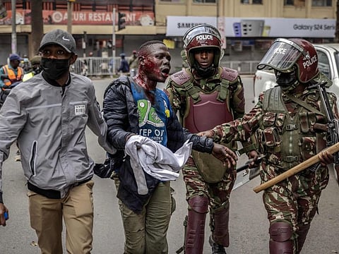 Kenya Police officers detain an injured man during an anti-government demonstration called following nationwide deadly protests over tax hikes and a controversial now-withdrawn tax bill in downtown Nairobi, on July 2, 2024.