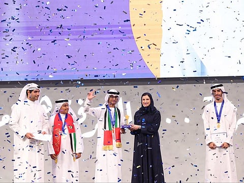 Ahmed Faisal Ali (centre) being honoured by Sarah bint Yousef Al Amiri, Minister of State for Public Education and Advanced Technology, during the award ceremony at Dubai World Trade Centre on Tuesday