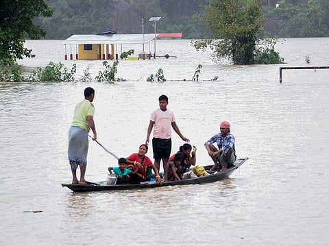 Villagers flee to a safer place in flood-affected Sildubi Village, in Morigaon in Assam on Tuesday.