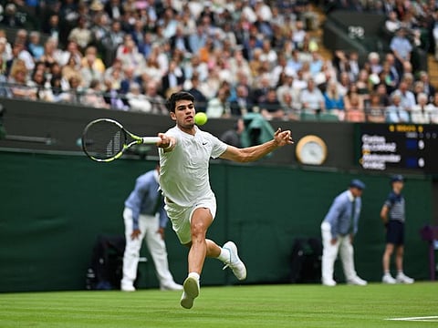Spain's Carlos Alcaraz returns against Australia's Aleksander Vukic during their men's singles second round tennis match on the third day of the 2024 Wimbledon Championships at The All England Lawn Tennis and Croquet Club in Wimbledon, southwest London, on S