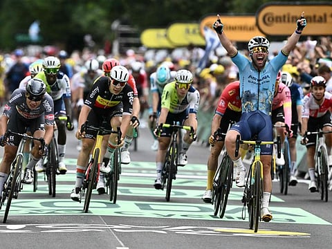 Astana Qazaqstan Team's British rider Mark Cavendish celebrates as he cycles past the finish line to win the 5th stage of the 111th edition of the Tour de France cycling race on Wednesday.
