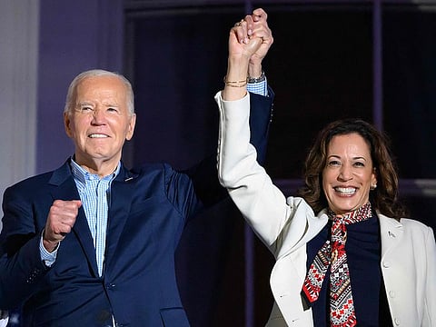 US President Joe Biden (L) and US Vice-President Kamala Harris hold hands and gesture as they watch the Independence Day fireworks display from the Truman Balcony of the White House in Washington, DC, on July 4, 2024.