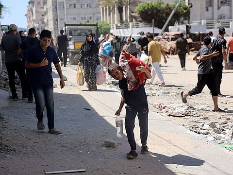 Palestinians flee the area following a warning by the Israeli military to evacuate during the Israeli military bombardment of Gaza City on July 7, 2024.