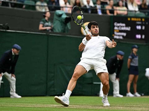 Spain's Carlos Alcaraz returns the ball to USA's Tommy Paul during their men's singles quarter-finals tennis match at The All England Lawn Tennis and Croquet Club in Wimbledon, southwest London, on Tuesday.