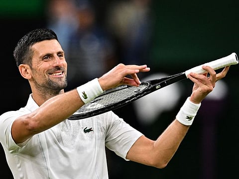 Serbia's Novak Djokovic pretends to play the violin for his daughter as he celebrates winning against Denmark's Holger Rune at The All England Lawn Tennis and Croquet Club in Wimbledon, southwest London, on July 8.