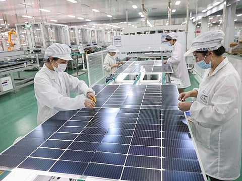 Employees working on solar photovoltaic modules that will be exported at a factory in Lianyungang, in China's eastern Jiangsu province.