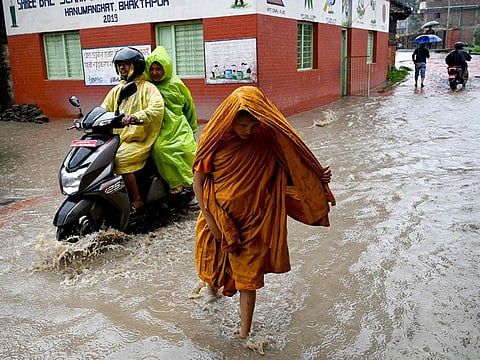 People wade through flood after Hanumante river overflowed following heavy rain in Bhaktapur on the outskirts of Kathmandu.