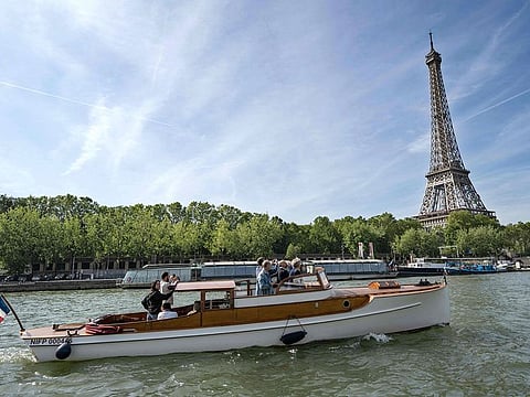 Visitors take picture of the Eiffel Tower in a "Taxi Seine Paris" boat, a new shuttle service on the Seine river deserving two stopovers at the Louvre and the Bourdonnais.