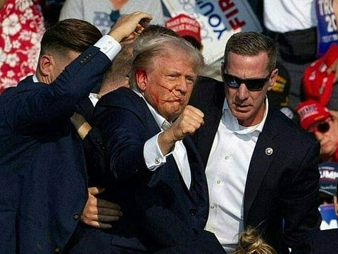 Republican candidate Donald Trump is seen with what appears to be blood on his face surrounded by secret service agents as he is taken off the stage at a campaign event at Butler Farm Show Inc. in Butler, Pennsylvania.