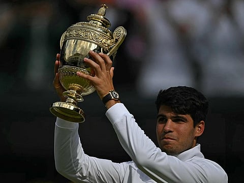 Spain's Carlos Alcaraz poses with the winner's trophy after beating Serbia's Novak Djokovic during their men's singles final tennis match of the 2024 Wimbledon Championships at The All England Lawn Tennis and Croquet Club in Wimbledon, southwest London, on Sunday.