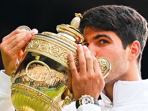 Spain’s Carlos Alcaraz shows the winner’s trophy following his 6-2, 6-2, 7-6 victory against Serbia’s Novak Djokovic in the men’s singles final of the Wimbledon tennis championships in southwest London on July 14, 2024. It was Alcaraz’s second Wimbledon win in a row.