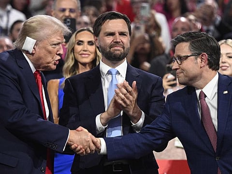 US Senator from Ohio and 2024 Republican vice-president candidate J. D. Vance looks on as US former President and 2024 Republican presidential candidate Donald Trump shakes hands with House Speaker Mike Johnson during the first day of the 2024 Republican National Convention at the Fiserv Forum in Milwaukee, Wisconsin, July 15, 2024.