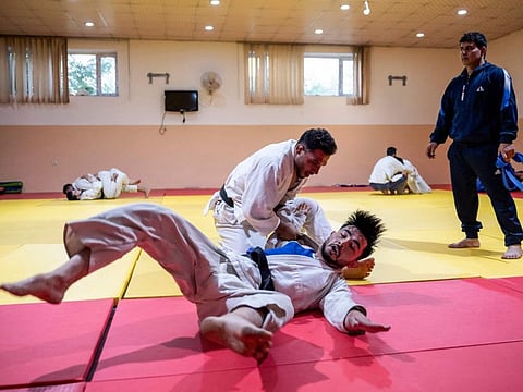 Afghan judo fighter Mohammad Samim Faizad (top) takes part in a training session with fellow judoka Shamsuddin Payenda Zadah at the Afghanistan Judo Federation in Kabul.