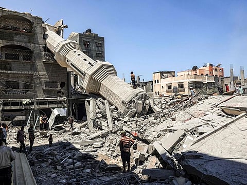 People search the rubble of destroyed buildings near the collapsed minaret of a mosque following Israeli bombardment in Nuseirat in the central Gaza Strip on July 17, 2024.