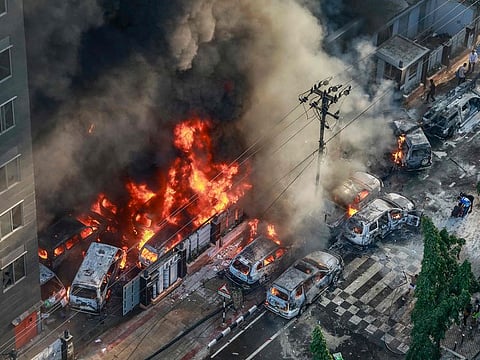Smoke rises from the burning vehicles after protesters set them on fire near the Disaster Management Directorate office, during the ongoing anti-quota protest in Dhaka on July 18, 2024. Bangladeshi students set fire to the country’s state broadcaster on July 18, a day after Prime Minister Sheikh Hasina appeared on the network seeking to calm escalating clashes that have killed at least 32 people.