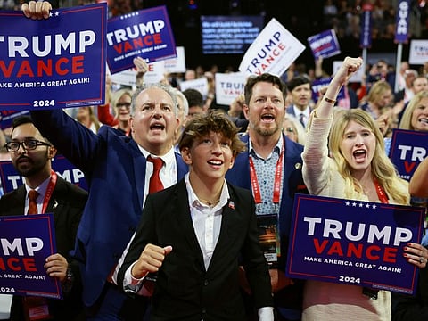 People hold signs on the third day of the Republican National Convention at the Fiserv Forum on July 17, 2024 in Milwaukee, Wisconsin.