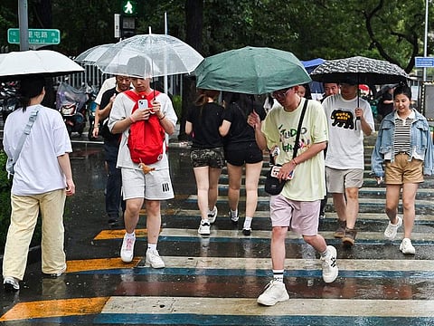 People use umbrellas to shelter from heavy rain in Beijing.