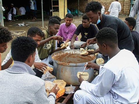 Volunteers in a charity provide meals at a displacement camp in Gedaref city in the east of war-torn Sudan.
