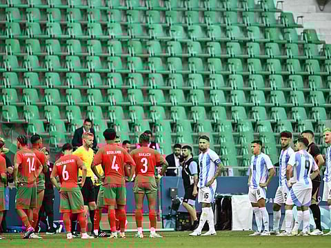 Swedish referee Glenn Nyberg (6thL) looks on as Argentina's and Morocco's players prepare to start playing again in the men's group B football match at the Geoffroy-Guichard Stadium.