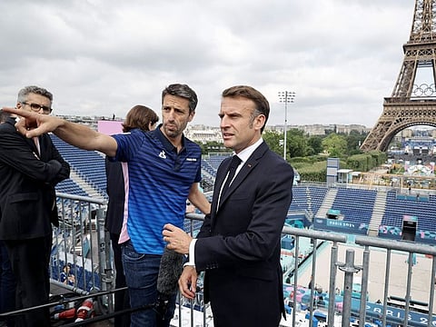 French President Emmanuel Macron (right) and President of the Paris 2024 Olympics Organising Committee Tony Estanguet visit the “Stade Tour Eiffel” in Champ-de-Mars in Paris on July 24, 2024, ahead of the Paris Olympic Games. The “Stade Tour Eiffel” will host beach volleyball.