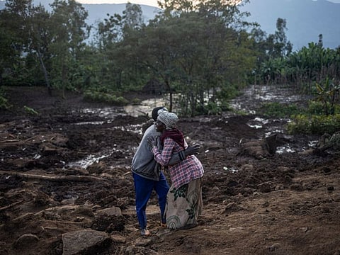 A hugs a man after residents and volunteers left for the night after digging in the mud in search for survivors and bodies at the scene of a landslide in Gofa on July 24, 2024.